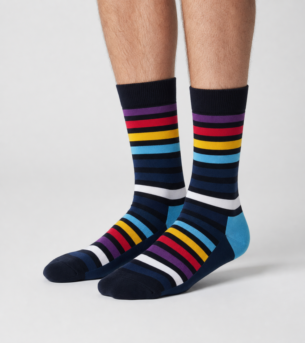 A pair of crew socks with a geometric 3D cube pattern in blue, olive green, mustard yellow, navy, and white, worn on a model&
